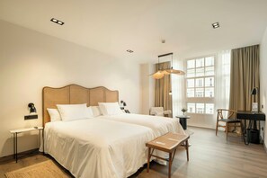 A hotel room with two beds, a desk, a chair, a lamp, and a large window with curtains. - Hotel Sercotel EsteOeste (Lugo)