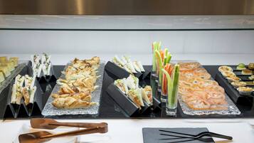 A buffet with various food items including sandwiches, salads, and appetizers.