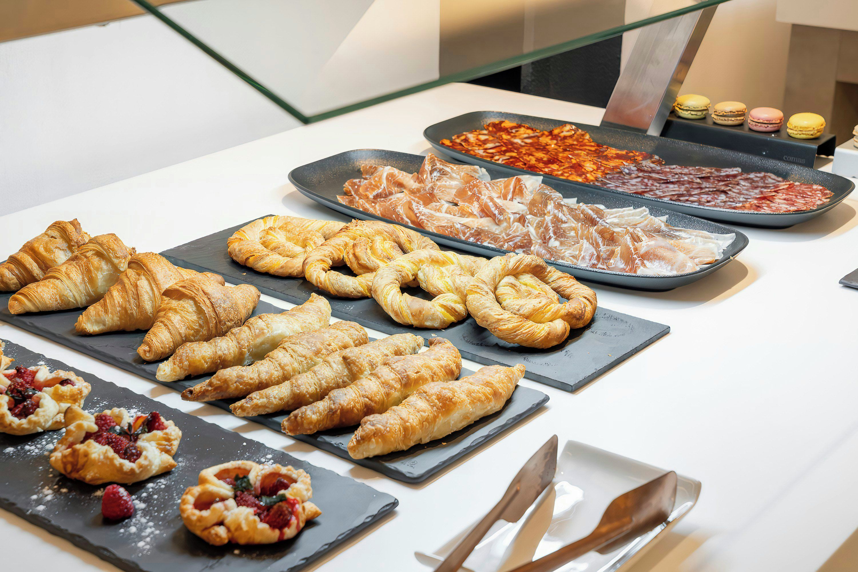 Een buffet met diverse gebakjes en vleessoorten.