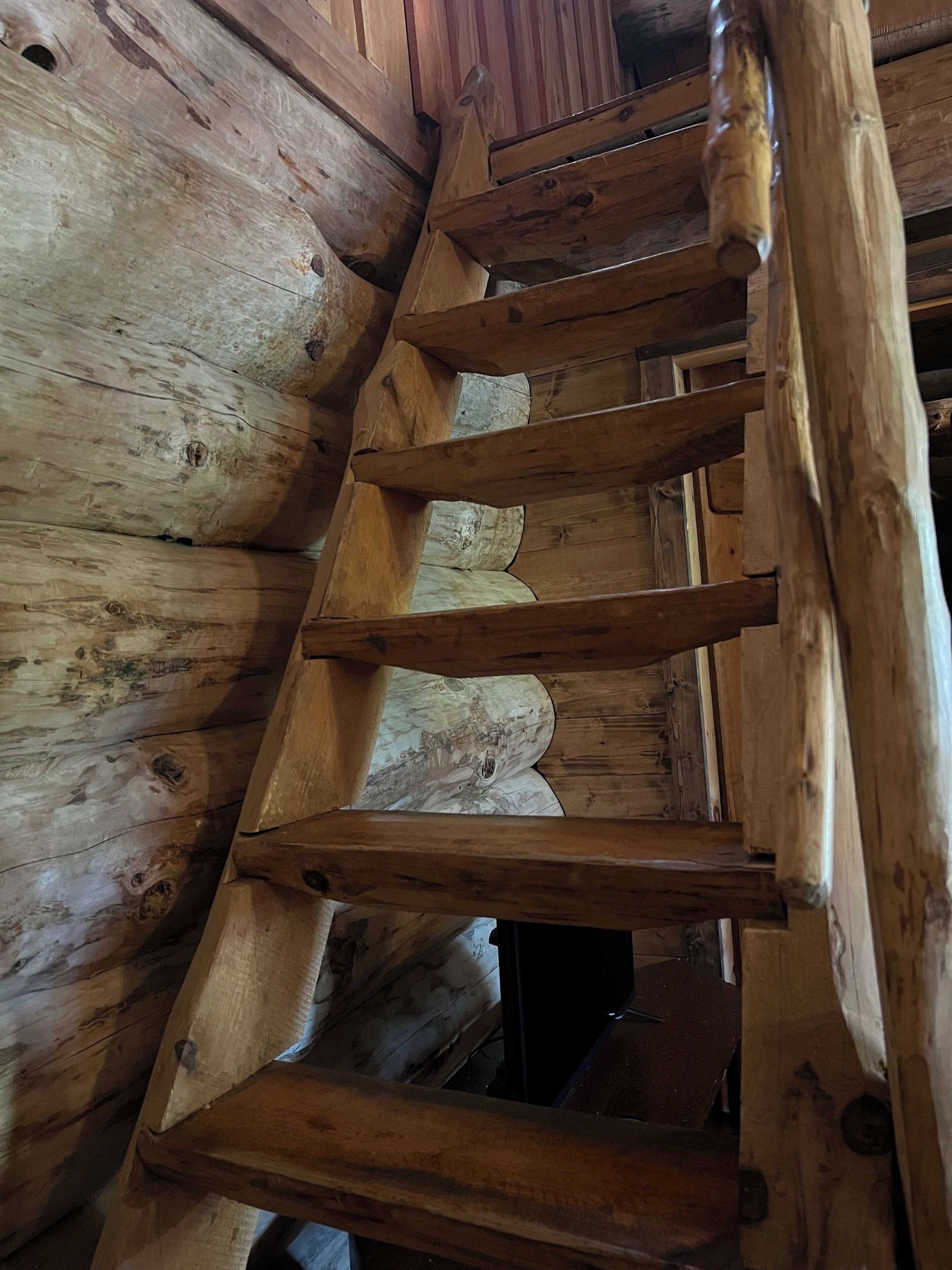 Una escala espirall de fusta a l'interior d'una cabana de fusta.