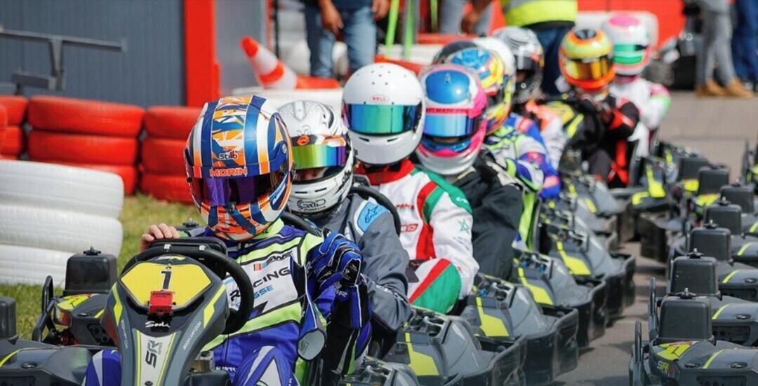 A group of racing motorcycles lined up on a track.