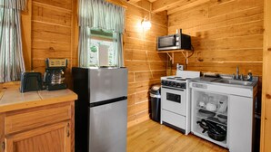 Une cuisine compacte équipée d’un réfrigérateur, d’un four à micro-ondes, d’une cuisinière et d’un évier.