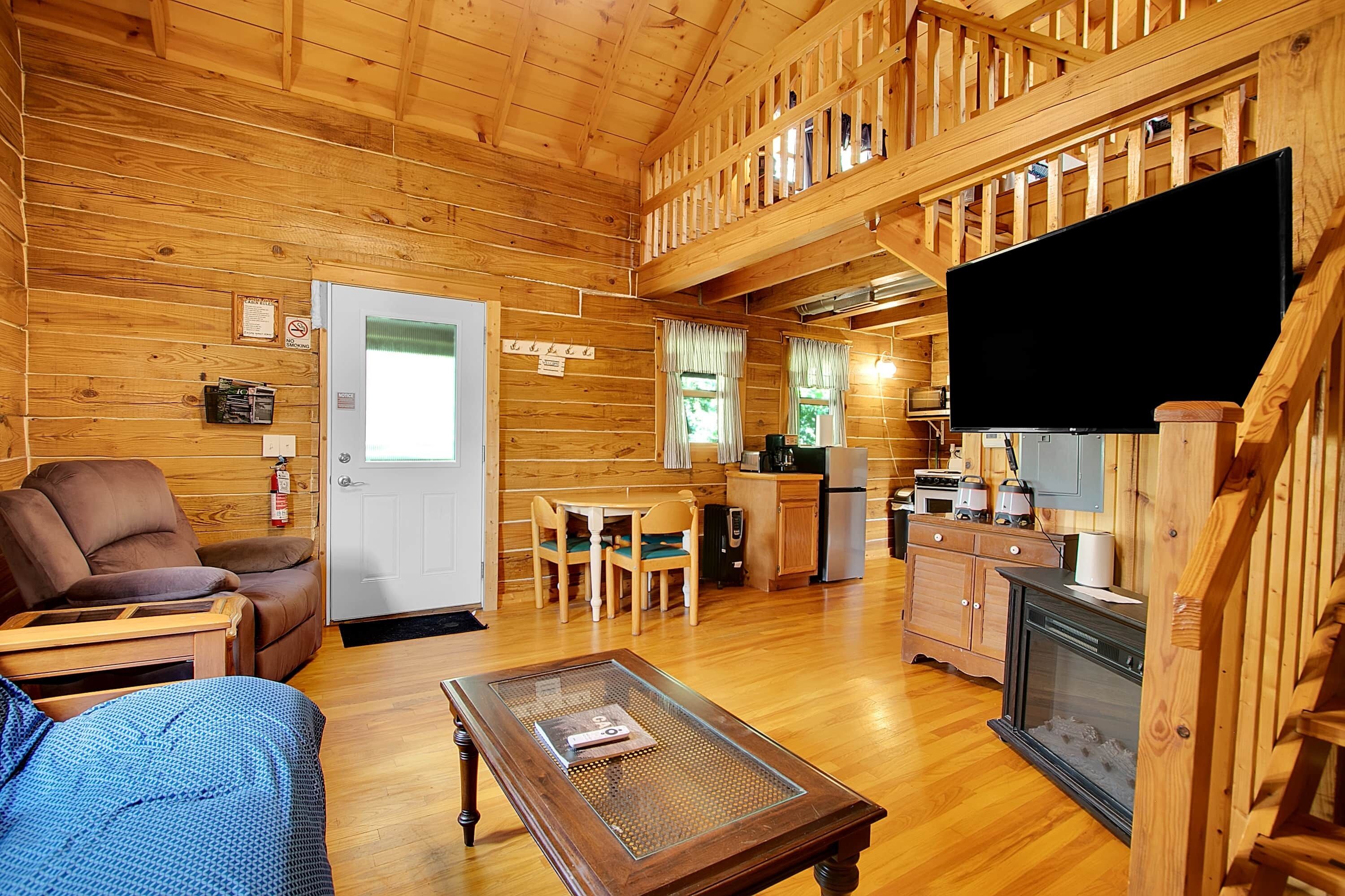 Ein gemütliches Blockhaus-Interieur mit Wohnbereich, Essbereich, Küche und Kamin.