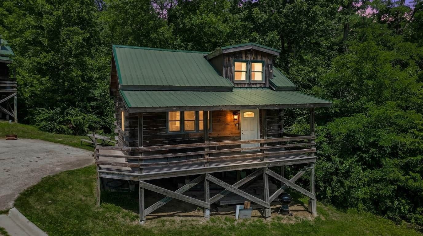 Eine rustikale Holzhütte mit Veranda und kleiner Holzterrasse.
