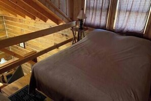 Ein Schlafzimmer mit Holzbalkendecke und einem Bett.