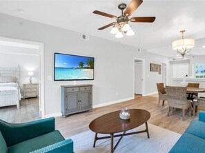 Relax in this stylish living area with a flat-screen TV, dining table, and comfortable seating.