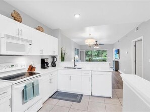 Enjoy cooking in this well-equipped kitchen with a stovetop, microwave, and large island with a sink.