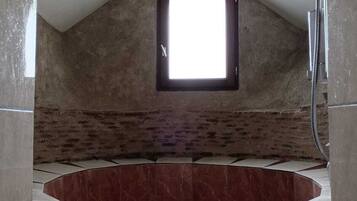 Un bagno con finestra a soffitto, doccia e vasca da bagno.
