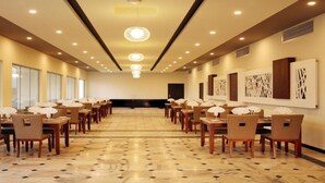 A spacious conference room with a long table and chairs, large windows, and artwork on the walls. - Haffa House  (Salalah)