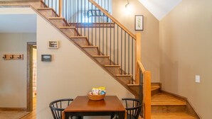 Una escalera de madera con barandilla de metal que lleva a un piso superior.