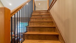 Una escalera de madera con barandillas negras que conduce a un piso superior.