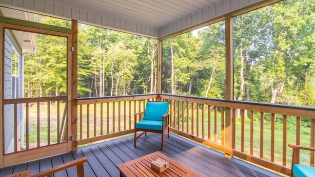 A covered deck with a wooden bench, a table, and a chair. - Monarch Cabin | WiFi & River Access (Elkin)