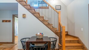 A staircase with wooden steps and a wooden handrail, leading to an upper floor. - Monarch Cabin | WiFi & River Access (Elkin)