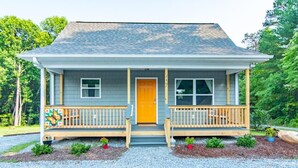 A two-story house with a front porch, a front door, and a mailbox. - Monarch Cabin | WiFi & River Access (Elkin)
