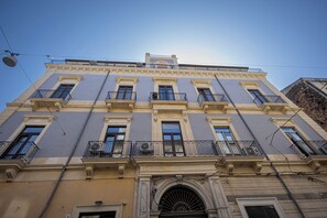 A multi-story building with a symmetrical facade, multiple balconies, and a central entrance with an arched doorway. - Catania Center B&B (Catania)