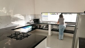 Eine moderne Küche mit Gasherd, Mikrowelle und einer Person, die kocht.