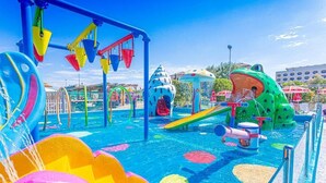 Un espace de jeux aquatiques avec des toboggans et une fontaine en forme de grenouille.
