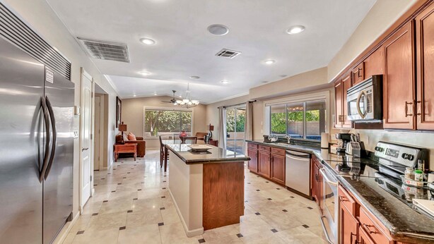 A modern kitchen with a central island, stainless steel appliances, and a view to the outdoors. - Listing Description has Discounts! Kierland Home w/Pool & Hot Tub & Nearby Park! (Scottsdale)