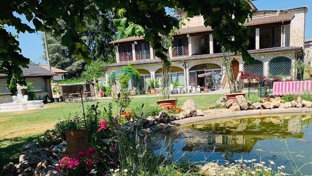 A stone building with a pond, surrounded by a garden with various plants and flowers. - Bed and Breakfast Simonelli RoomS (Rocca Priora)