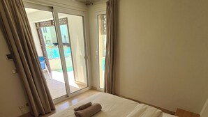 Une chambre d’hôtel avec un lit, une fenêtre et une vue sur une piscine.