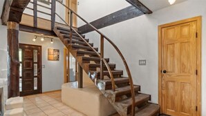 A spiral staircase with wooden steps and a beige landing area.
