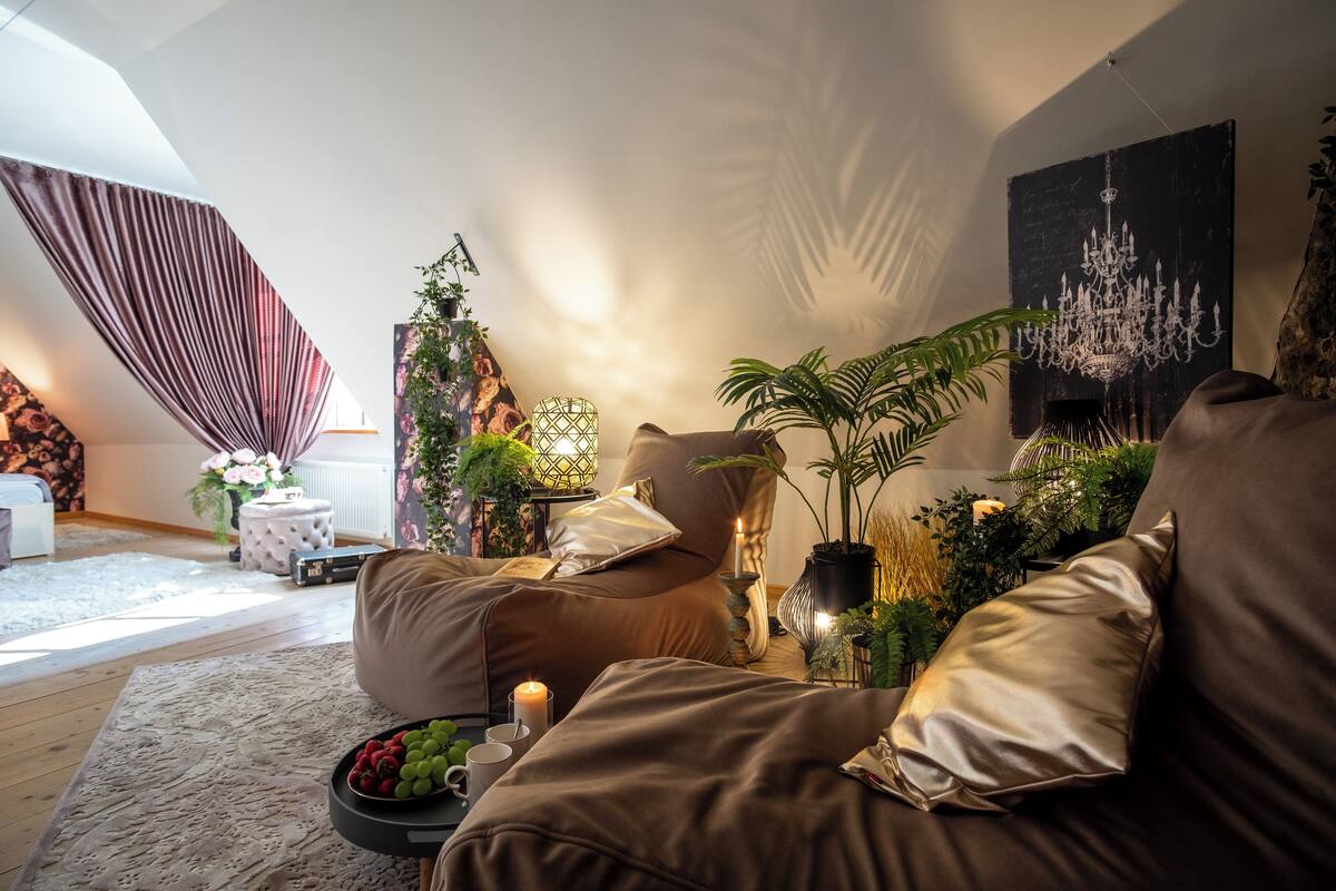 Ein gemütliches Wohnzimmer mit einem braunen Sofa, einem kleinen Beistelltisch mit einer Kerze und einer Obstschale.