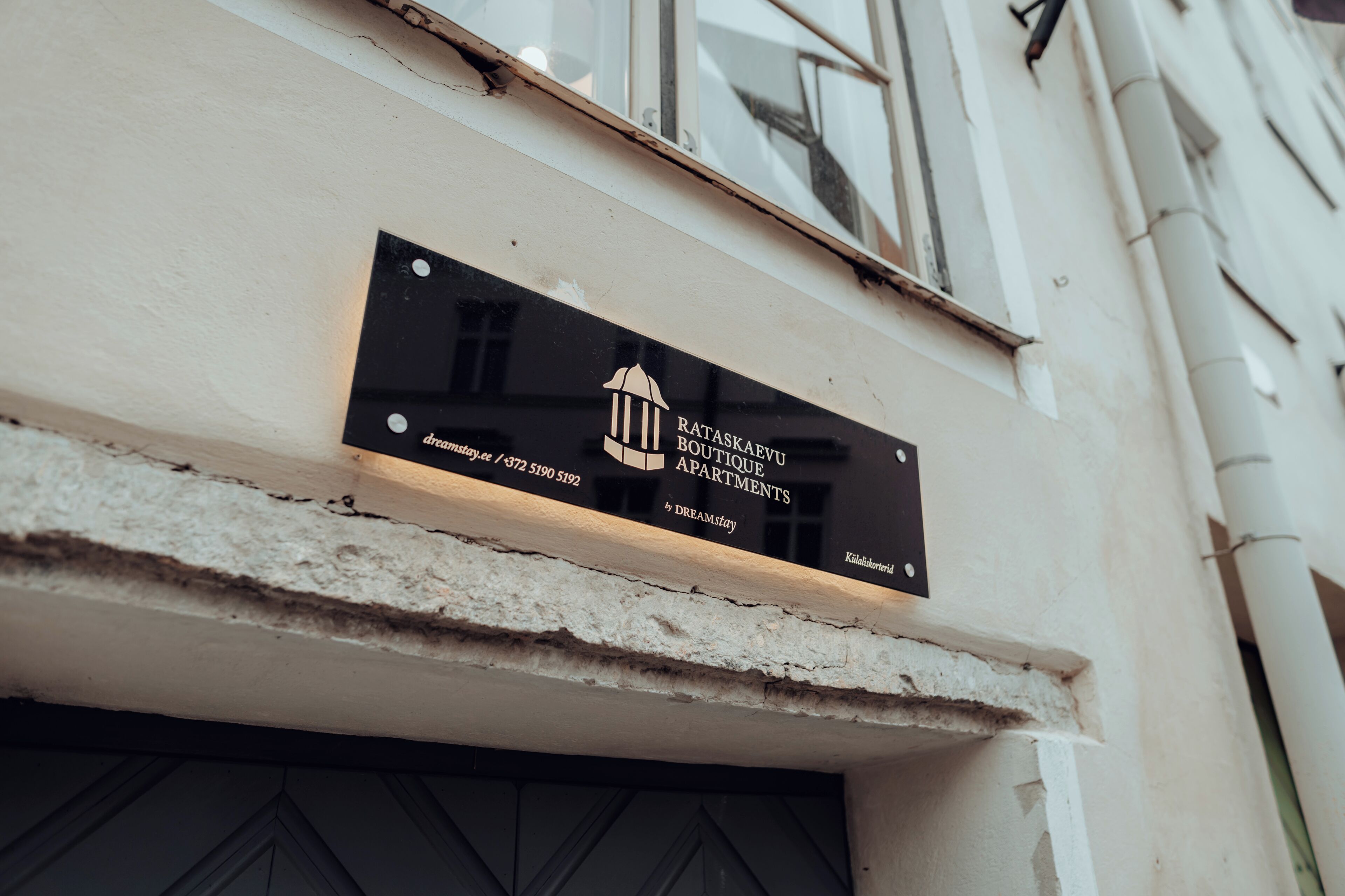Letrero de Rataskar Boutique Apartments con un número de contacto y logotipo.