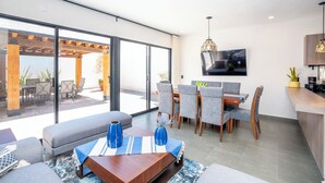 A modern living room with a sofa, coffee table, and dining area. - 4BR Private Sanctuary with Pools and Gym (San Miguel de Allende)