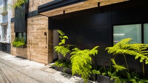 Een modern gebouw met houten lambrisering, grote ramen en kamerplanten.