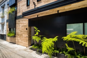 A modern building with wooden paneling, large windows, and indoor plants. - ULIV Roma Norte (Mexico City)