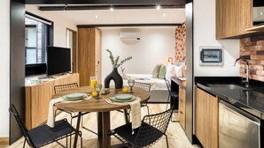 Een knus woongedeelte met een eethoek, kitchenette en een bed.
