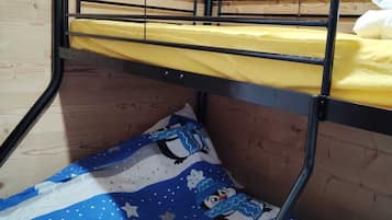 A bunk bed with a yellow mattress and a blue and white patterned blanket.