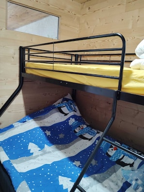 A bunk bed with a yellow mattress and a blue and white patterned blanket.