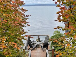 A deck with a table and chairs overlooking a body of water. - Your Inn on WHIDBEY ISLAND (Langley)