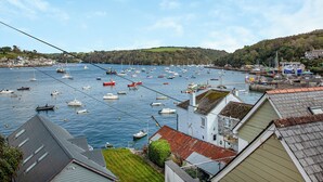 Un puerto con barcos, casas y un paisaje montañoso.