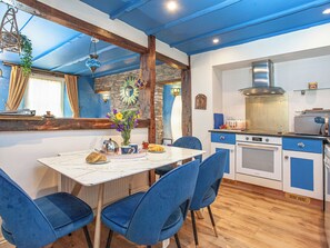 A dining area with a table, chairs, and a vase of flowers. - 2 bedroom accommodation in Polruan, near Fowey (Polruan, near Fowey)
