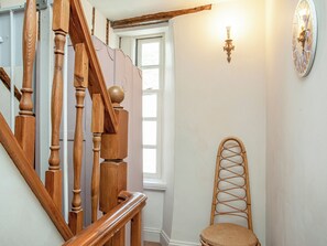 A wooden staircase with a handrail, a window, and a wall-mounted light fixture. - 2 bedroom accommodation in Polruan, near Fowey (Polruan, near Fowey)