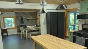 Una cocina con una isla central, un comedor con mesa y sillas, y una estufa.