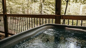 A wooden deck with a metal bathtub filled with water.