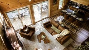 A spacious wooden cabin with a living area, dining space, and a kitchen.