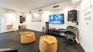 Un gimnasio con equipamiento de ejercicio, un saco de boxeo y decoración motivacional en la pared.