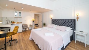 Un dormitorio moderno con una cama grande, un escritorio y una silla.