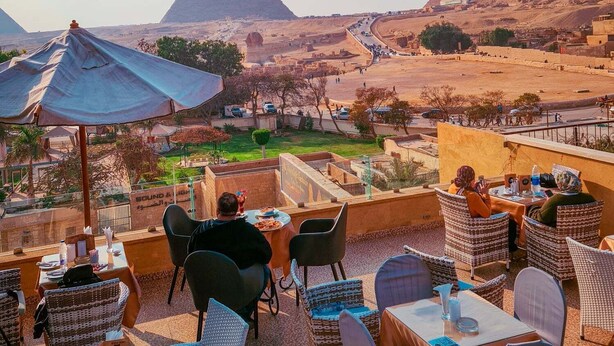 A dining area with tables and chairs overlooking the pyramids. - TUI Pyramids View  (Giza)