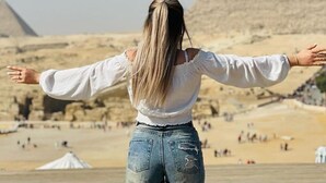 A person standing with arms outstretched in front of the pyramids. - TUI Pyramids View  (Giza)