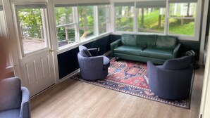 A cozy room with a green sofa, two armchairs, and a patterned rug.