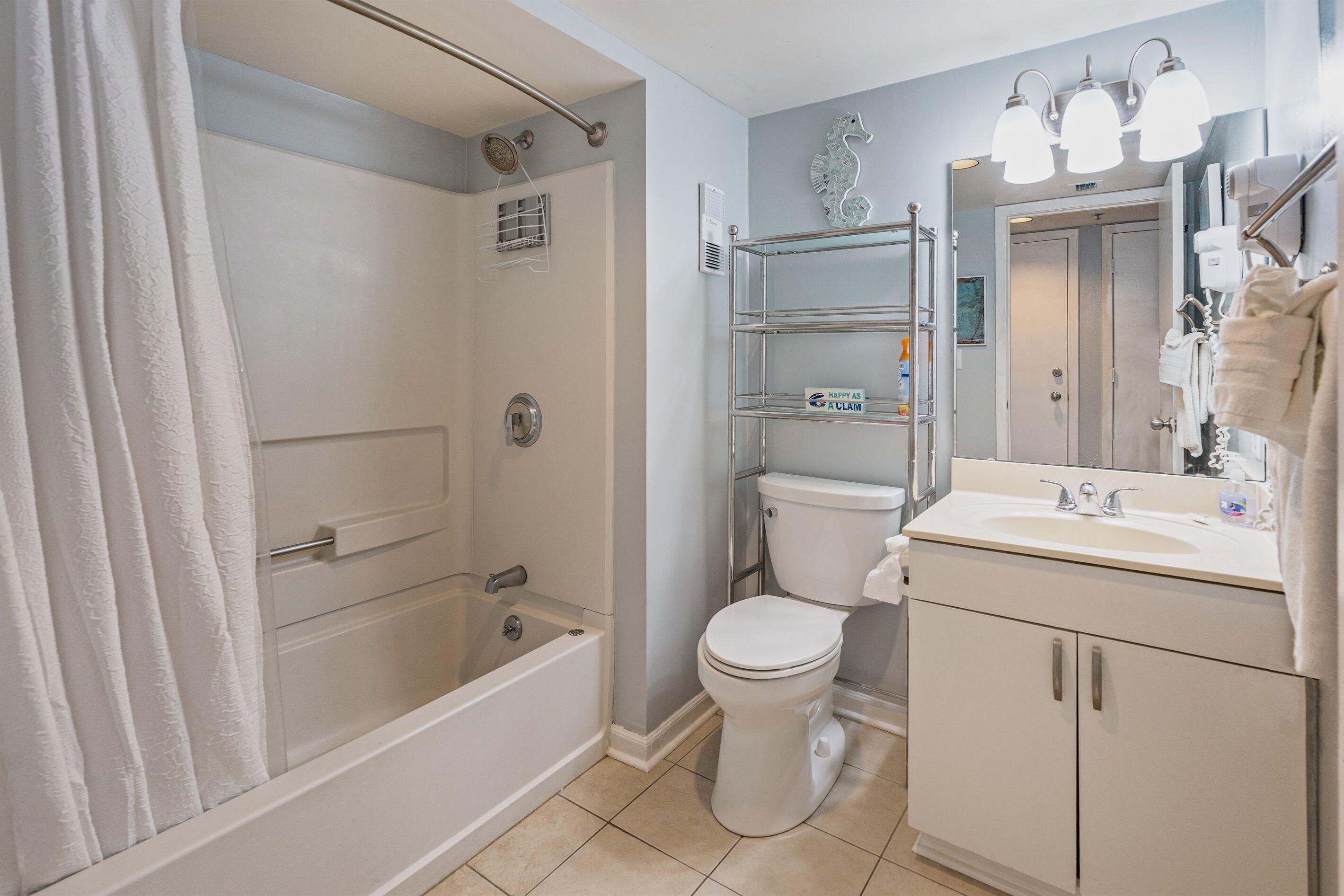 A bathroom with a bathtub, toilet, and a sink with a mirror.