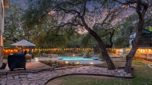 Ein Garten mit Pool, einem Kiesweg und Gartenmöbeln.