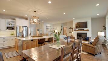 A spacious kitchen with wooden cabinets, a central island, and a dining area with a wooden table and chairs.