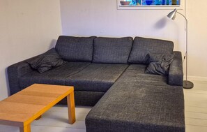 A grey sectional sofa with a wooden coffee table in front.