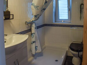 A bathroom with a bathtub, toilet, and sink. - The Annex at Tenniside (Perranporth)